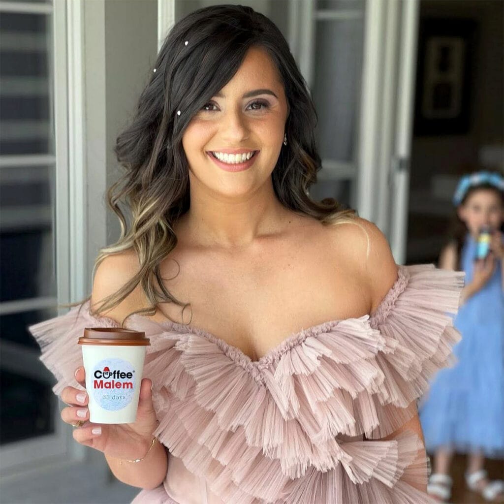 Bridal shower guest holding a Coffee Malem cup