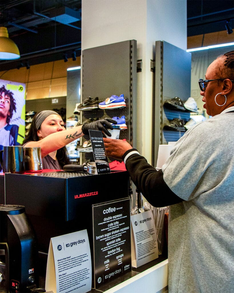 Coffee Malem barista serving a guest at a Grey Days retail activation in New York City