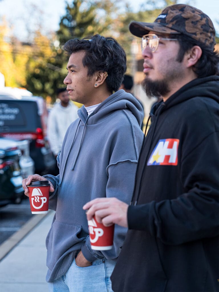 Guests holding Coffee Malem drinks at an outdoor cars and coffee event in the Philadelphia area.